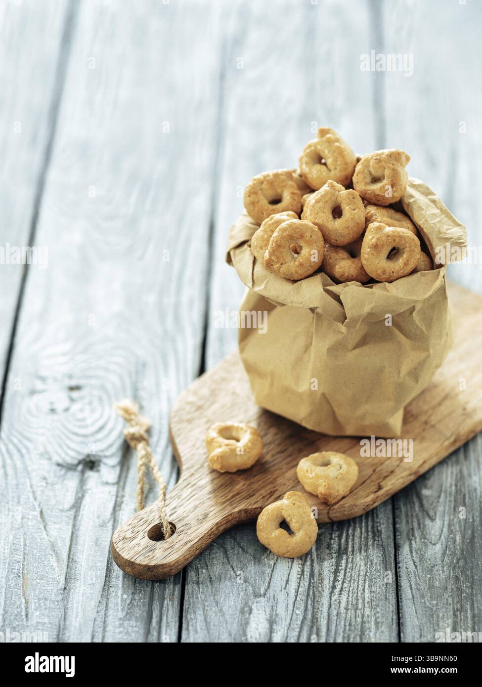 Taralli ou taralini italien traditionnel dans un sac en papier sur une ancienne table en bois grise. Photo rustique de taralli apéritif avec espace copie Banque D'Images