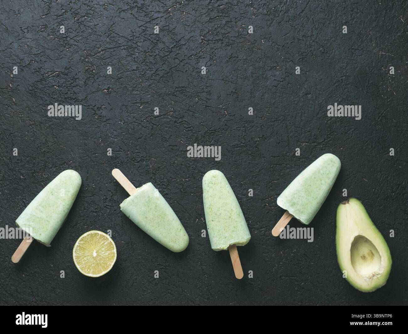 Végétalien premières maison lime avocat ma glace. Sans sucre, sans produits laitiers, crème glace verte sur fond texturé noir. Copier l'espace. Vue d'en haut. Idées et recettes Banque D'Images