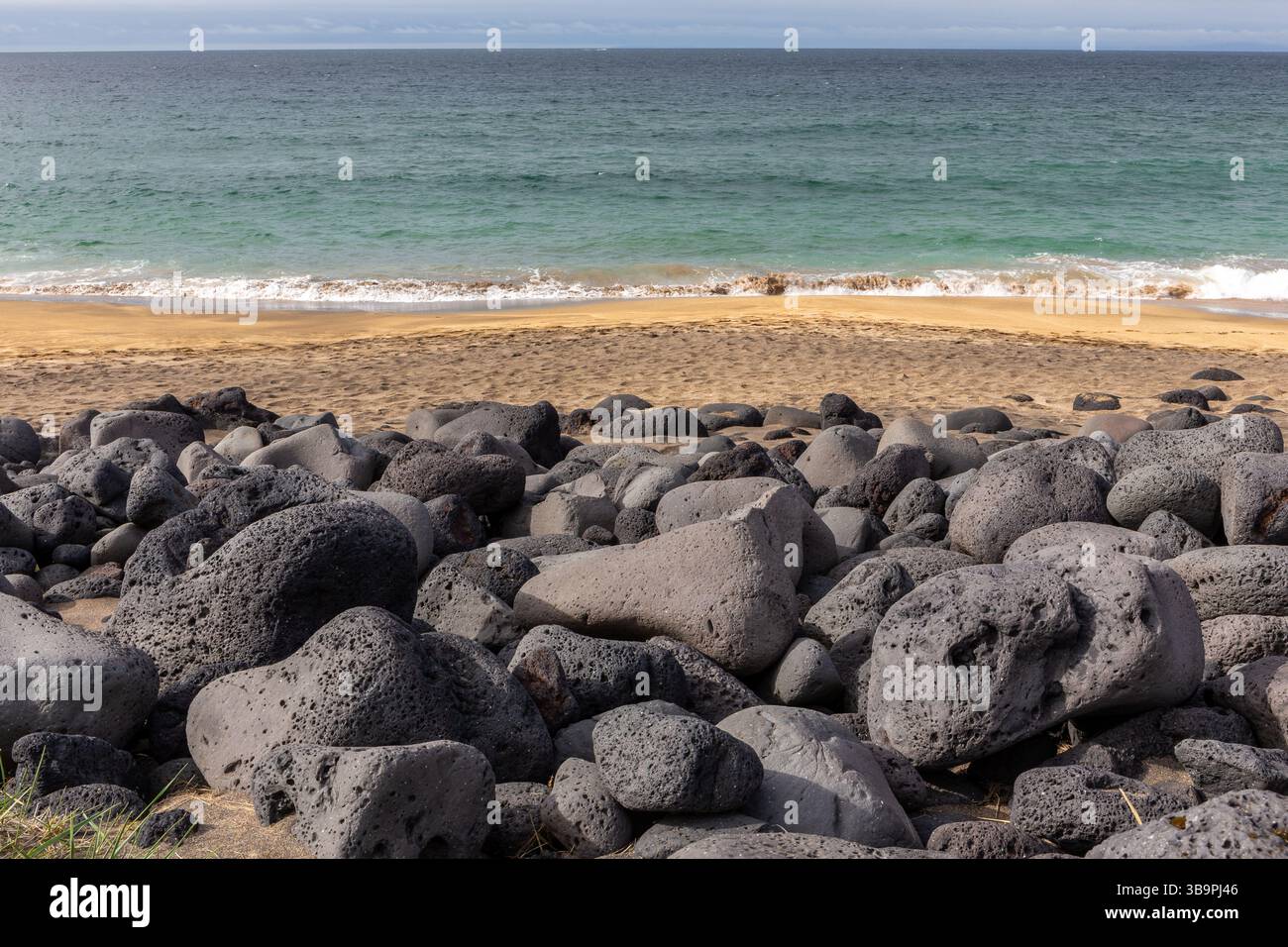 Cailloux volcaniques noirs et pierres sur la plage de Skardsvik sur la péninsule de Snaefellsnes en Islande, plage de sable doré avec de l'eau turquoise, les vagues s'écrasent. Banque D'Images