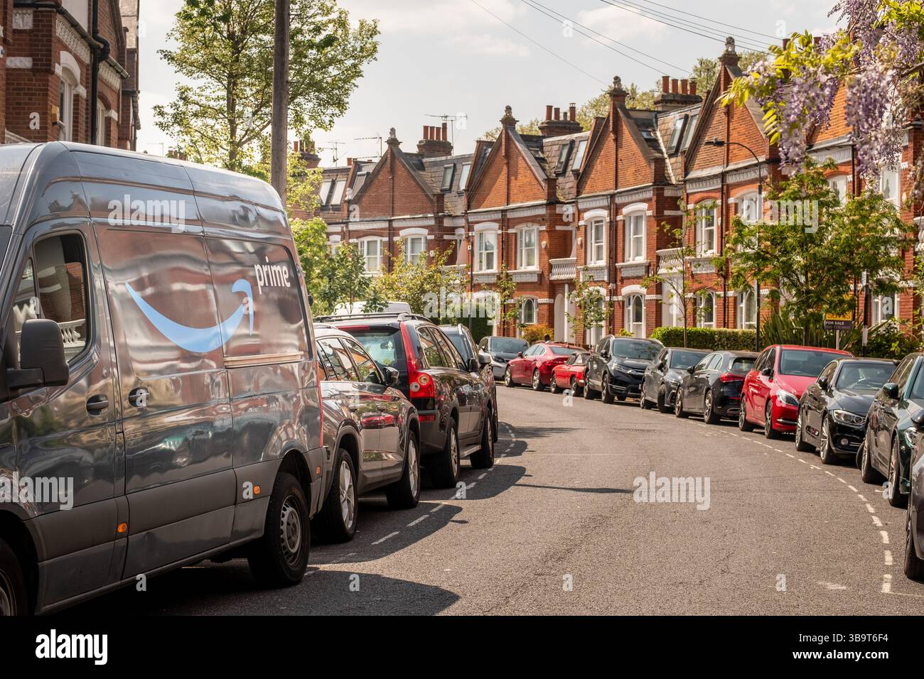LONDRES- 28 AVRIL 2025 : logo Amazon Prime sur le côté du camion de livraison sur la rue des maisons urbaines Banque D'Images