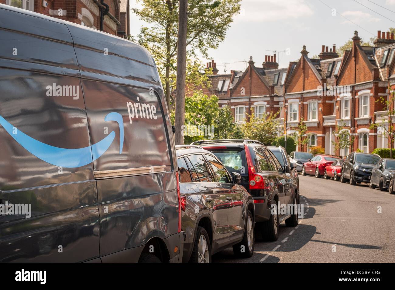 LONDRES- 28 AVRIL 2025 : logo Amazon Prime sur le côté du camion de livraison sur la rue des maisons urbaines Banque D'Images