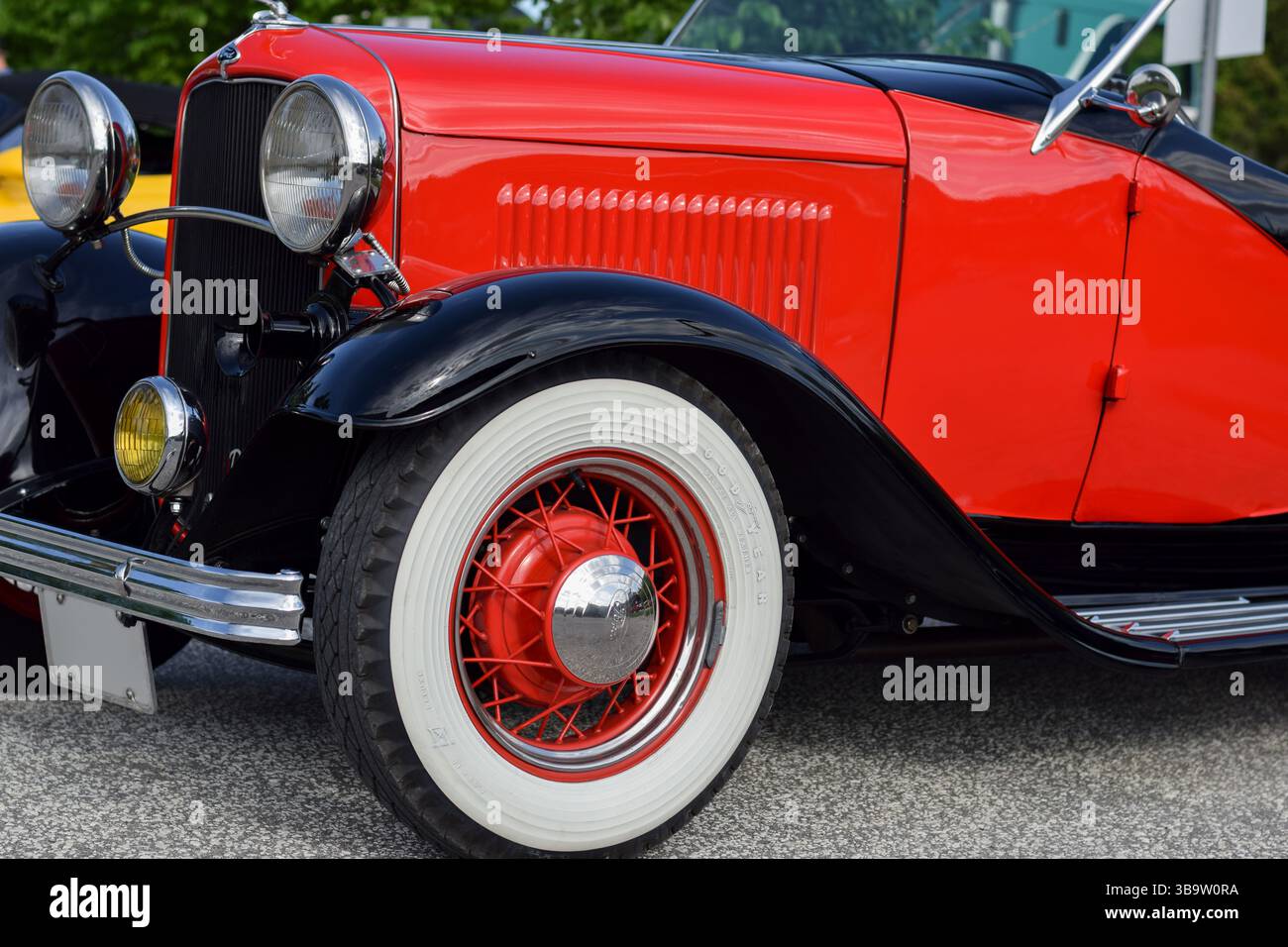 28 mai 2022 - East Gwillimbury, Ontario, Canada : vue du phare avant et de la roue Goodyear de la vieille voiture classique Ford rouge vintage 1932 modèle B. Banque D'Images