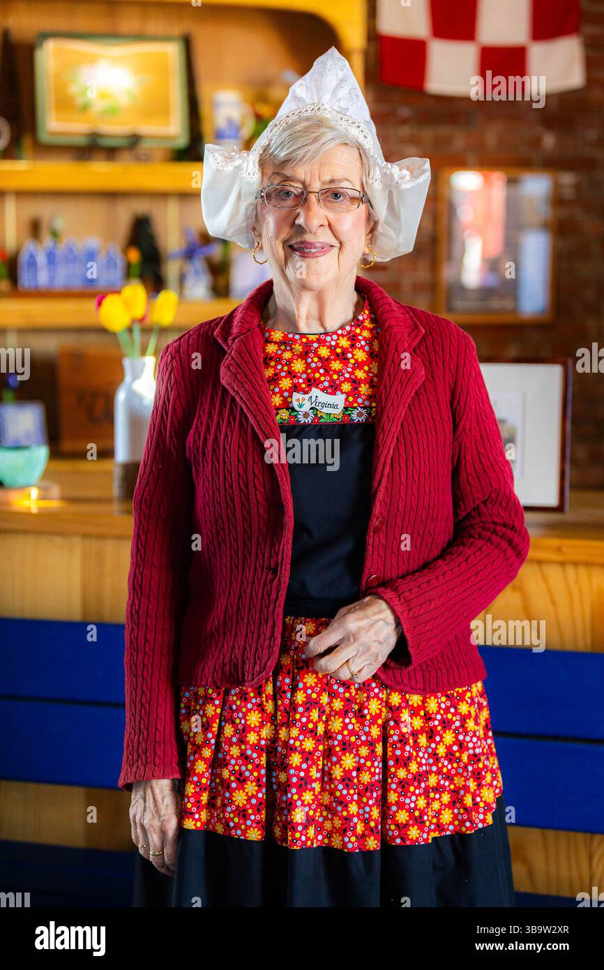 Holland, mi, USA - 04-24-2025 : portrait en gros plan d'une vieille femme souriante vêtue de vêtements traditionnels hollandais montrant la fierté culturelle et l'expres patrimonial Banque D'Images