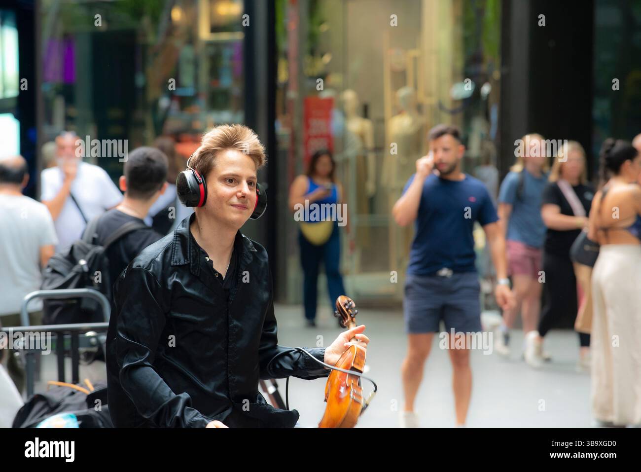 Jeune violoniste de rue, Vasiliy Shapkin se produisant au Pitt Street Mall, Sydney, Australie en décembre 2024 Banque D'Images