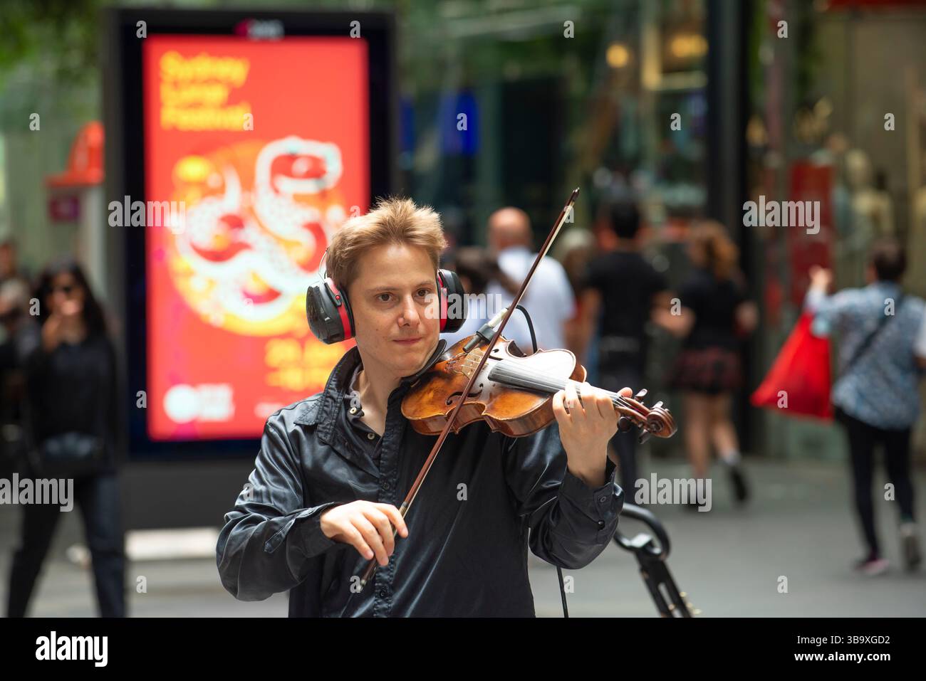 Jeune violoniste de rue, Vasiliy Shapkin se produisant au Pitt Street Mall, Sydney, Australie en décembre 2024 Banque D'Images