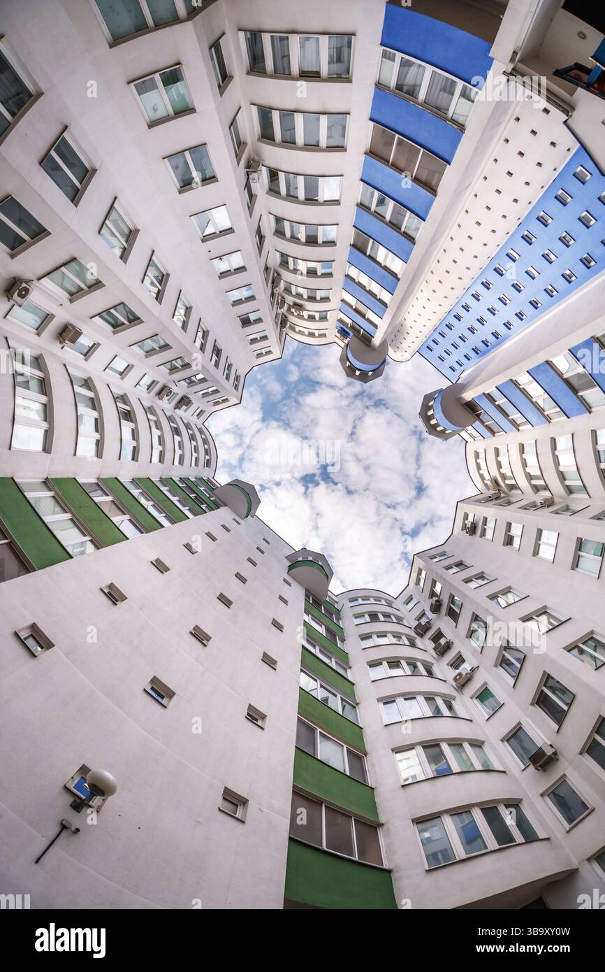 vue de bas en haut vers le ciel dans une maison gratte-ciel bien avec une cour étroite Banque D'Images