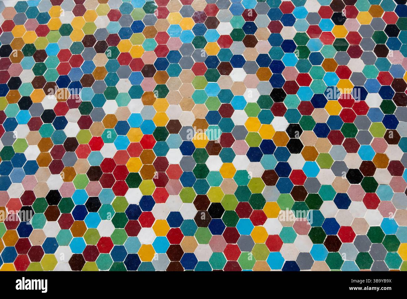 Fond coloré avec une mosaïque faite de petits carreaux octogonaux de différentes couleurs, représentatifs de la céramique traditionnelle marocaine, réalisée en atelier Banque D'Images