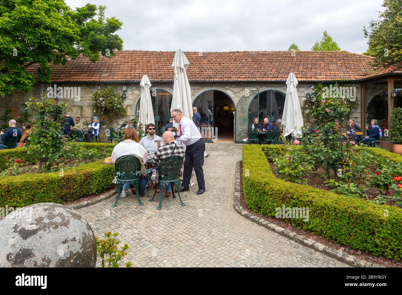 Les gens dégustant du vin de Porto dans le jardin au pavillon de vin de Porto Taylor, Porto, Portugal, Europe Banque D'Images