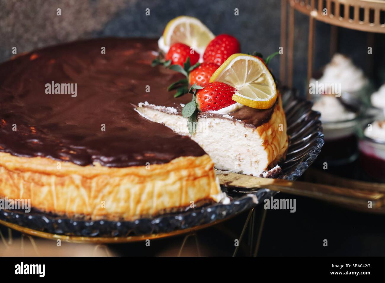 Cheesecake au chocolat avec des fruits. Trancher sur une assiette à dessert. Garniture de fraises et citron. Délicieuse friandise maison. Délicieux gâteau cuit au four Banque D'Images