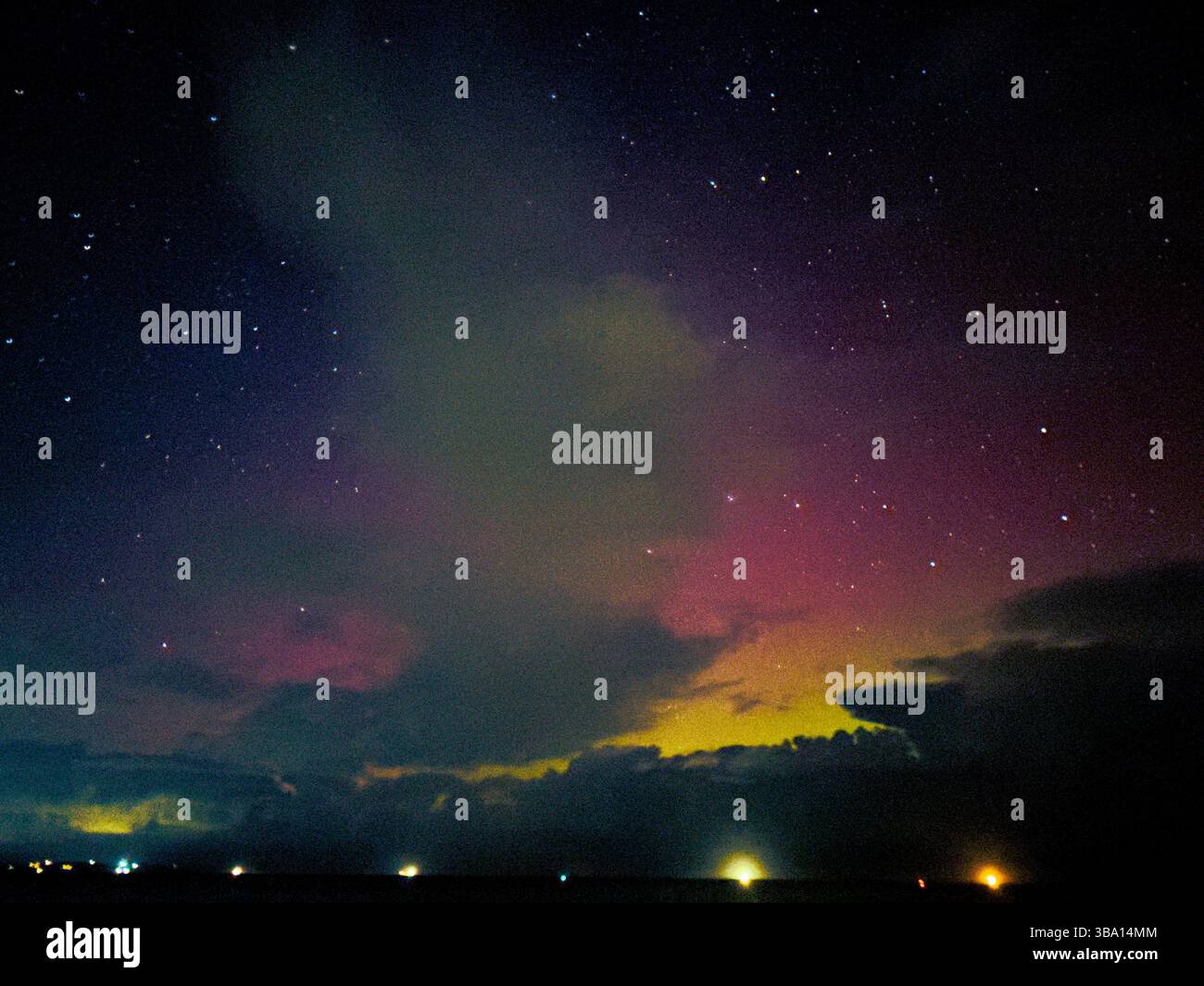 Urora borealis avec des teintes violettes et jaunes au-dessus de Penmon point, Anglesey, pays de Galles. Étoiles et nuages visibles. Prise le 5 novembre 2023. - Image de stock capturée avec un smartphone