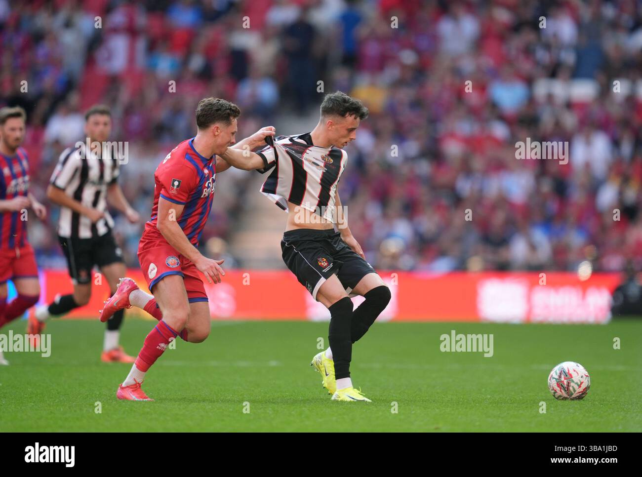Aaron Jones d'Aldershot Town (à gauche) et Corey McKeown de Spennymoor Town s'affrontent pour le ballon lors de la finale du Trophée Isuzu FA au stade de Wembley à Londres. Date de la photo : dimanche 11 mai 2025. Banque D'Images