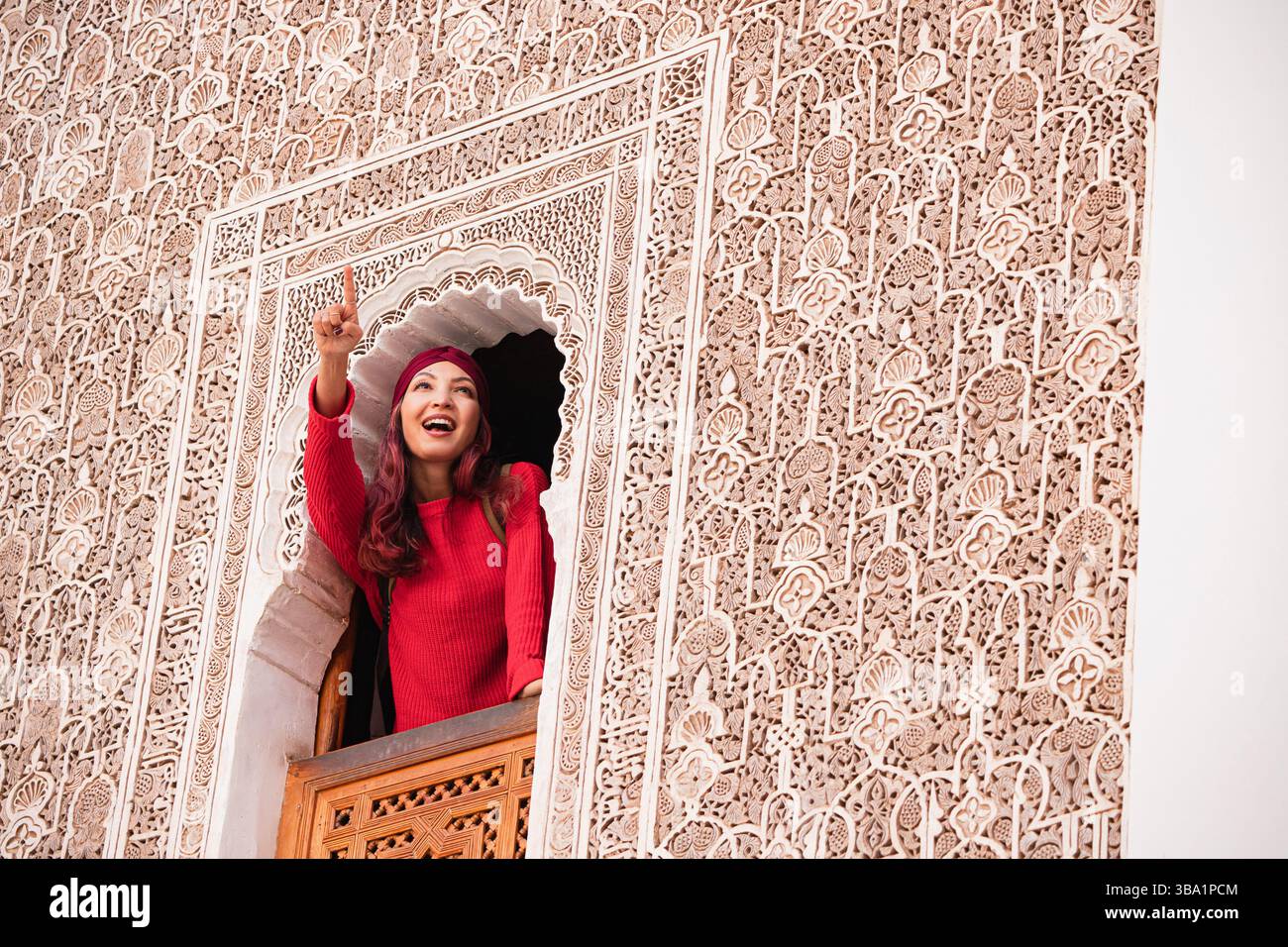 Jeune femme montrant des décorations marocaines traditionnelles lors de la visite de Ben Youssef Madrasa à Marrakech, Maroc Banque D'Images