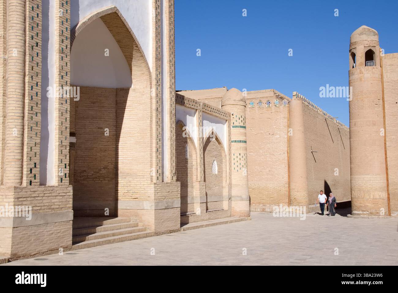 Deux personnes marchant dans la vieille ville à Itchan Kala, Khiva, Ouzbékistan Banque D'Images