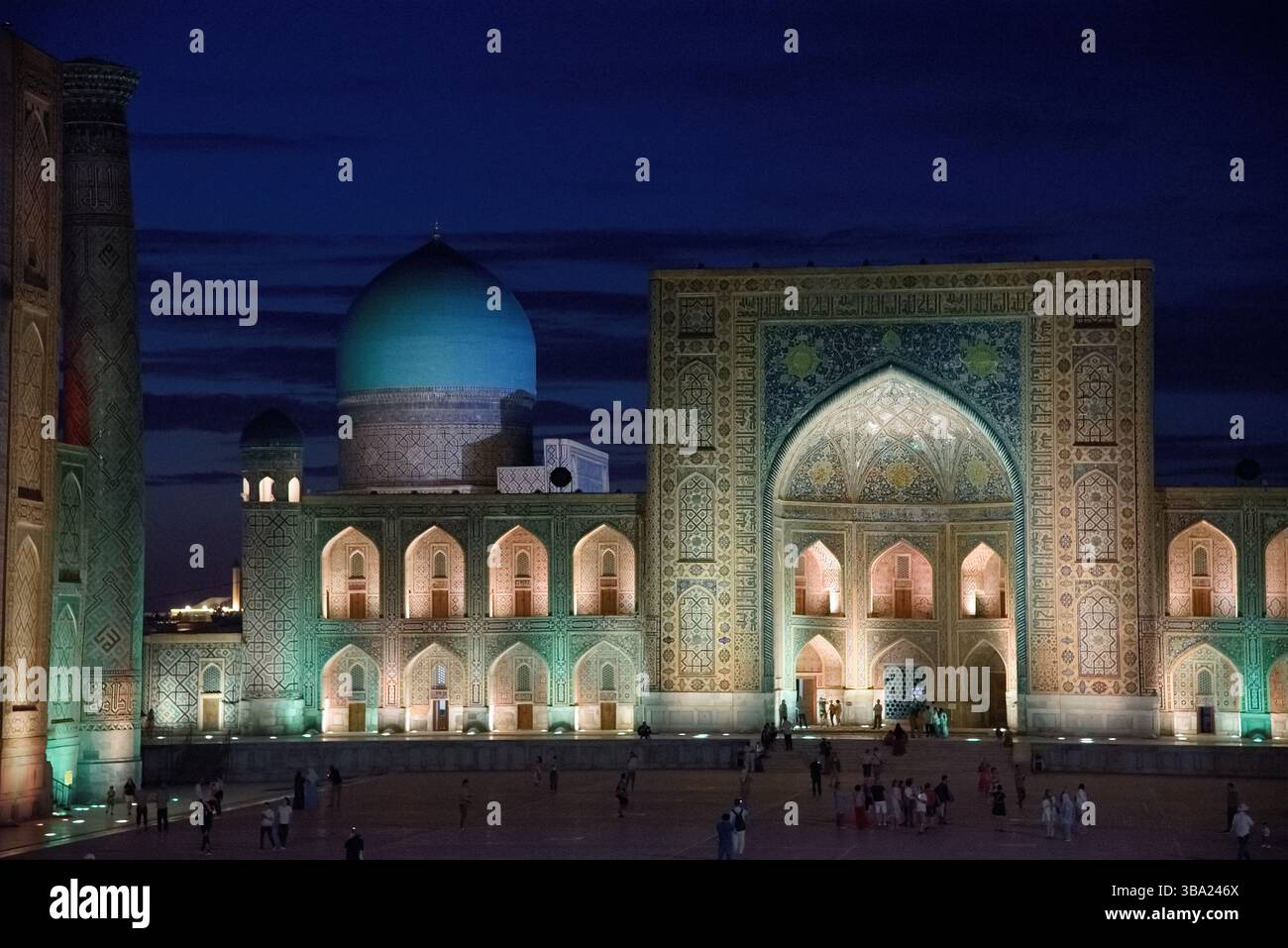 Dôme bleu illuminé et éclairage coloré dans la soirée à la Madrasa Tilya-Kori sur la place Registan à Samarcande, Ouzbékistan Banque D'Images