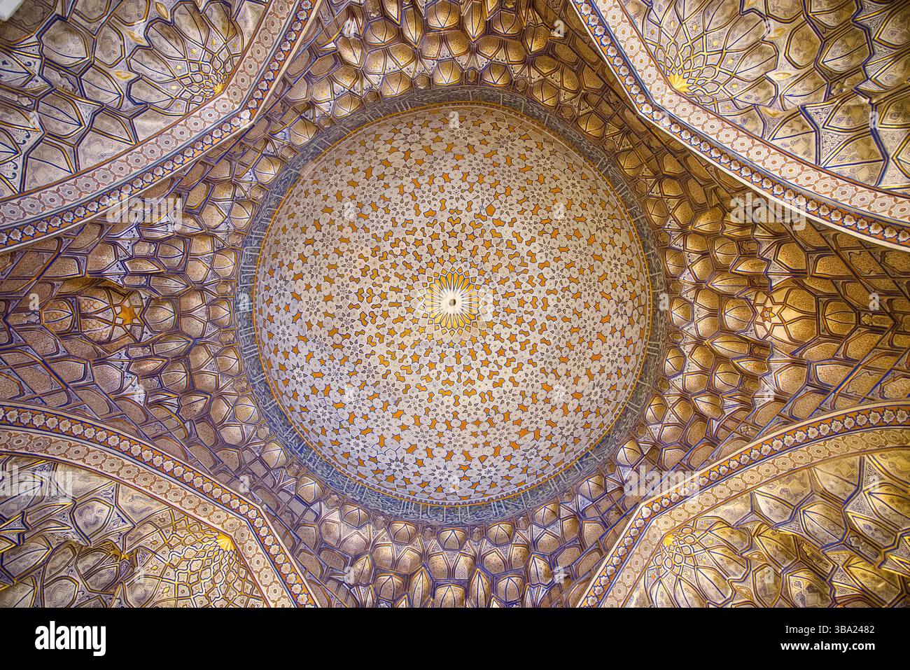 Regardant vers le haut le plafond intérieur richement décoré et doré d'un dôme dans la nécropole de Shah-i-Zinda à Samarcande, Ouzbékistan Banque D'Images