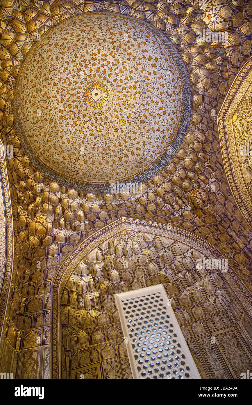 Regardant vers le haut le plafond intérieur richement décoré et doré d'un dôme dans la nécropole de Shah-i-Zinda à Samarcande, Ouzbékistan Banque D'Images