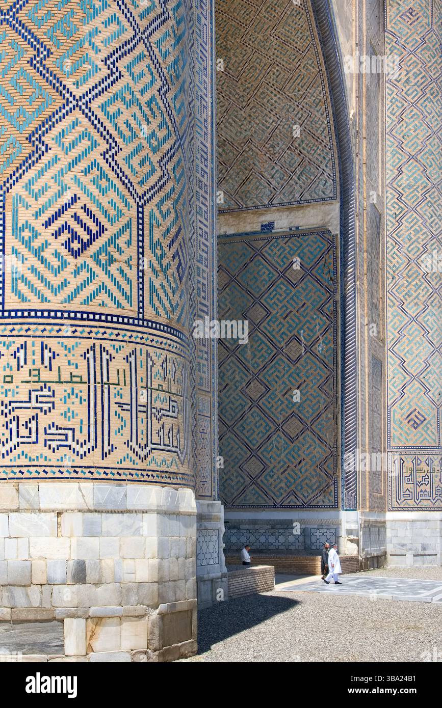 Les fidèles passant par l'immense entrée voûtée de la mosquée Bibi-Khanym à Samarcande en Ouzbékistan Banque D'Images