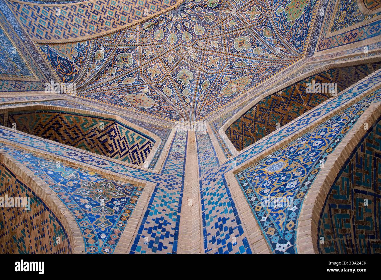 Une vue vers le haut sur l'entrée voûtée richement décorée et les galeries de la place Tilya-Kori Madrasan Registan à Samarcande en Ouzbékistan Banque D'Images