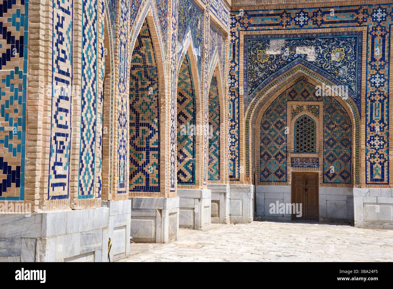 Une mosaïque richement décorée et carrelée d'entrées voûtées dans la Madrasa Tilya-Kori sur la place Registan Samarcande en Ouzbékistan Banque D'Images