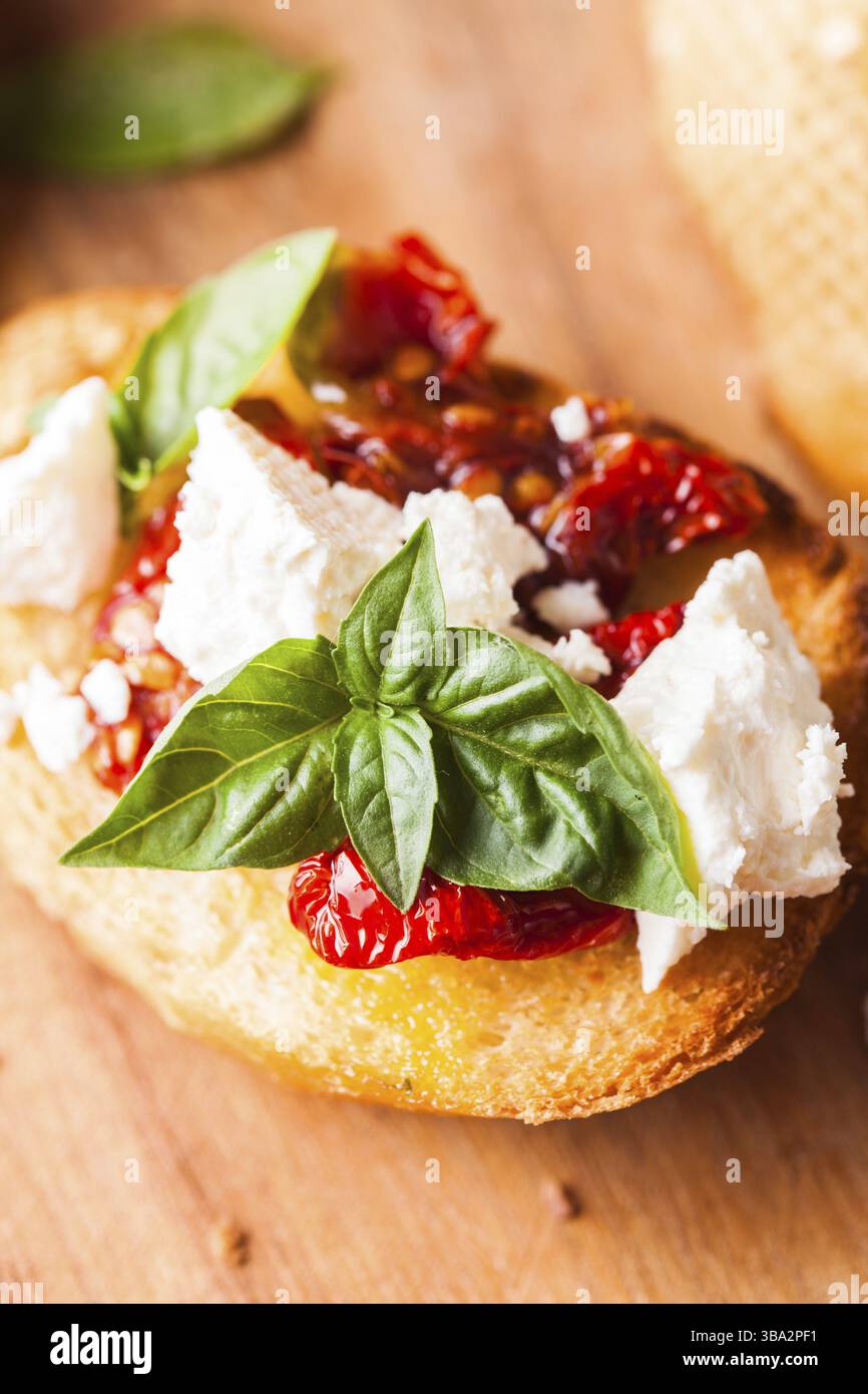 Bruschetta à l'huile d'olive, tomates séchées, feta et basilic frais Banque D'Images Bruschetta à l'huile d'olive, tomates séchées, feta et basilic frais Banque D'Images