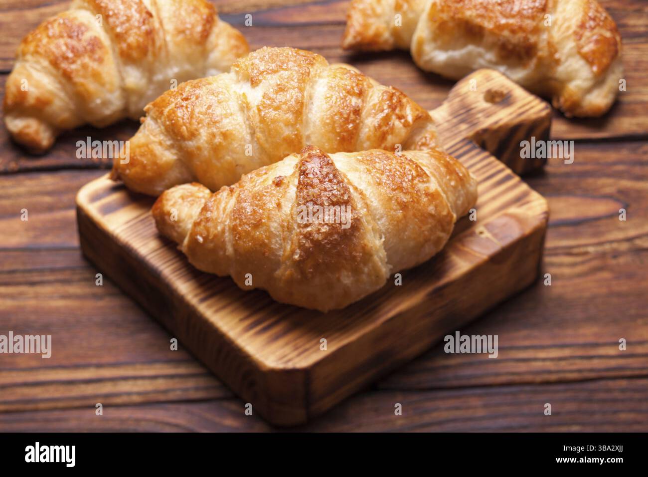 Deux délicieux croissants sur une planche à découper en bois Banque D'Images