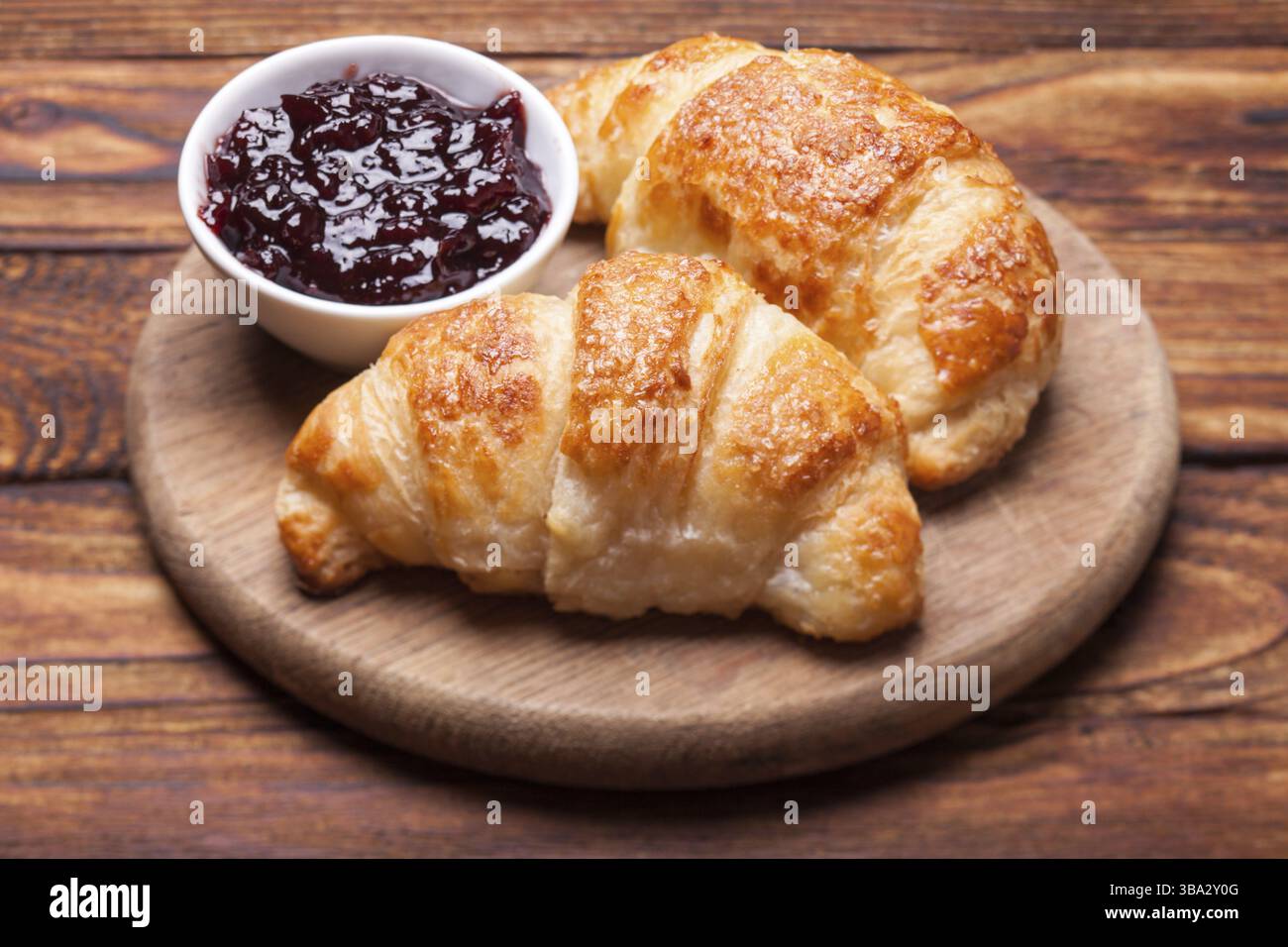 Deux délicieux croissants sur une planche à découper en bois Banque D'Images