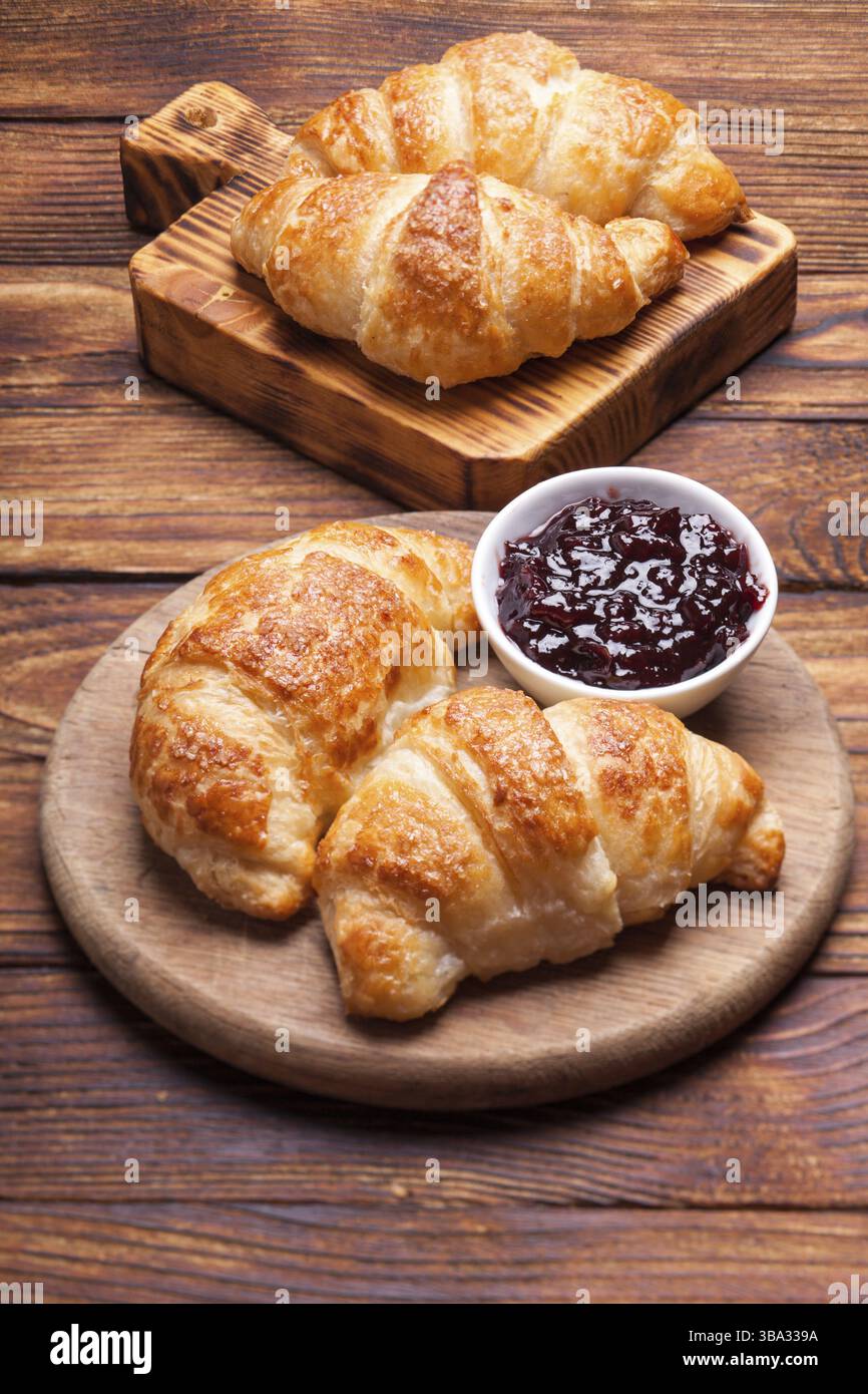 Deux délicieux croissants sur une planche à découper en bois Banque D'Images