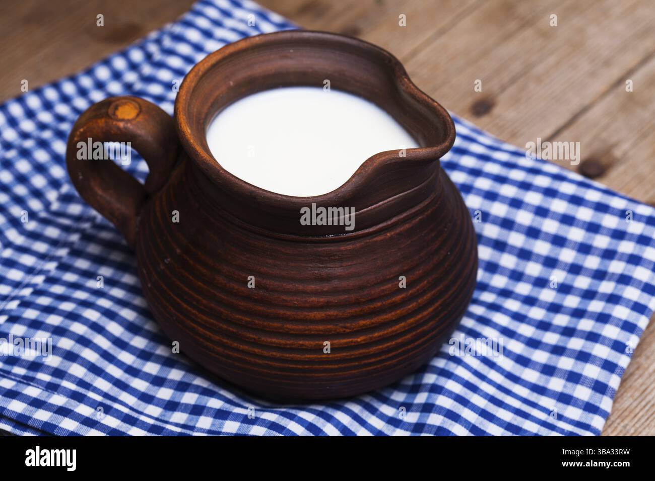 Cruche en argile pleine de lait dans un style rustique Banque D'Images
