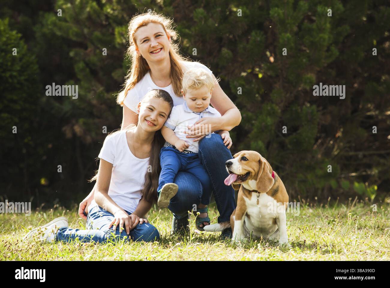 Mère heureuse avec sa fille, petit-fils et beagle chien Banque D'Images