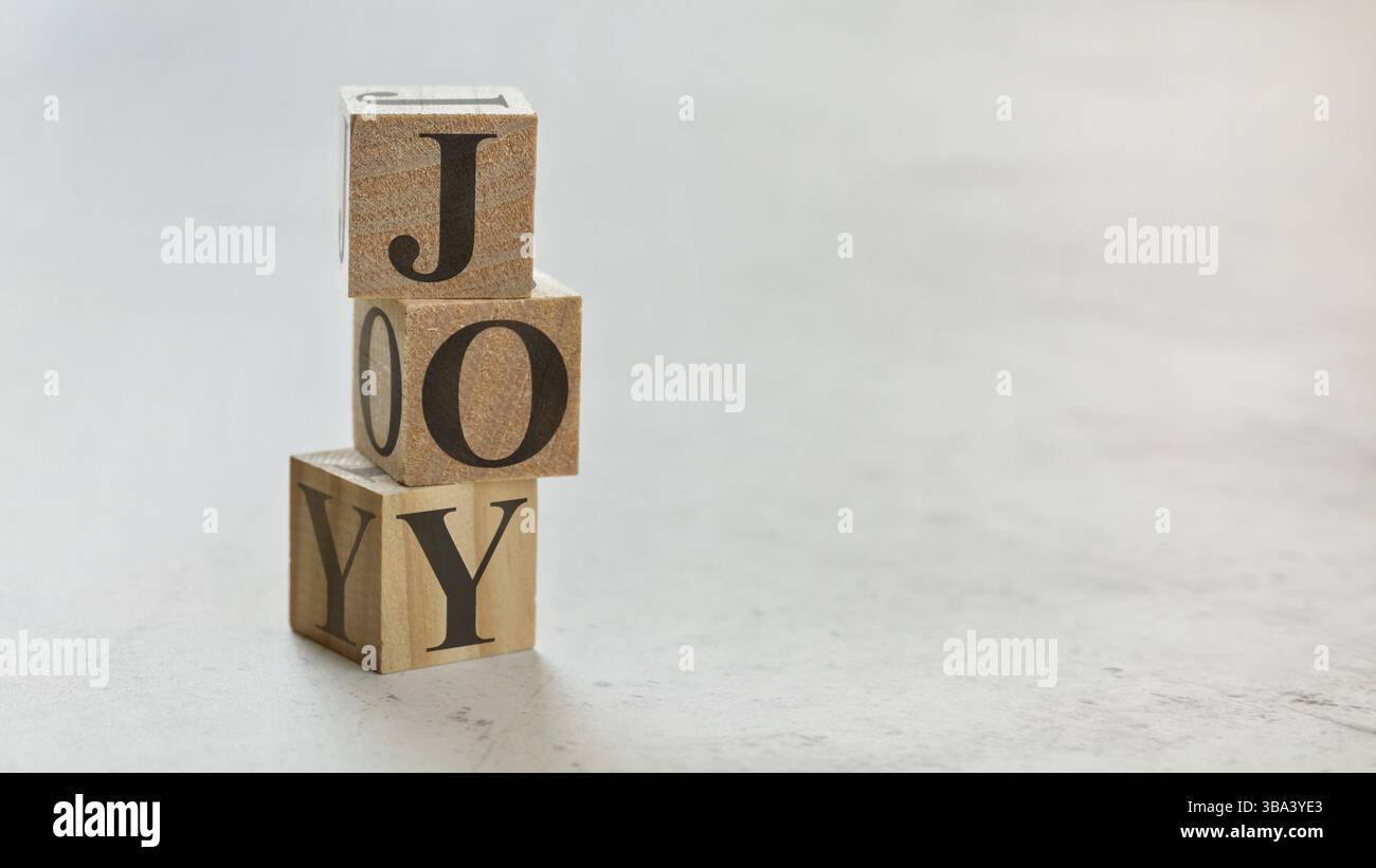 Pile avec trois cubes en bois - lettres JOIE sur eux, espace pour plus de texte / images sur le côté droit, Liptovsky Hradok, Slovaquie, Europe Banque D'Images