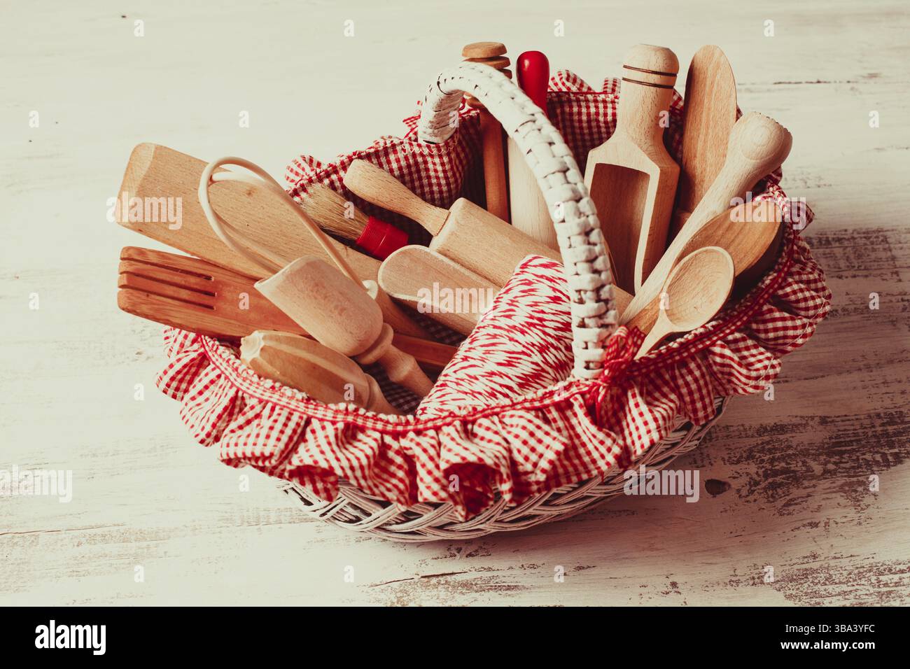 Panier rustique chic minable avec des ustensiles de cuisine en bois Banque D'Images