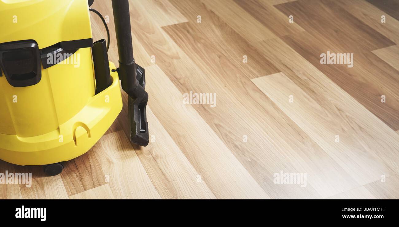 Détail de la machine d'aspirateur jaune sur plancher stratifié en bois - espace pour le texte côté droit, Liptovsky Mikulas, Slovaquie, Europe Banque D'Images