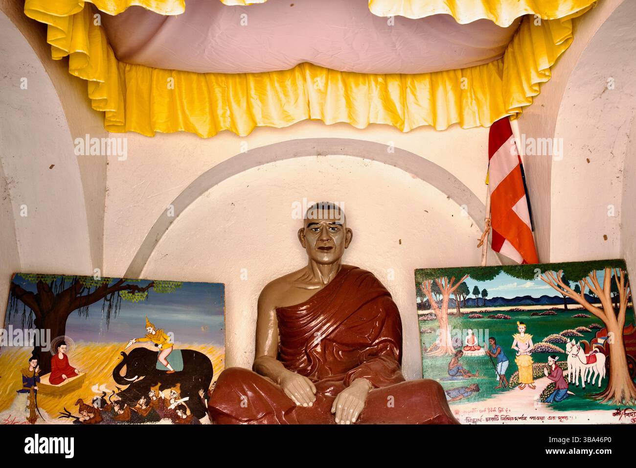 Statue grandeur nature d'un moine vénéré et panneaux muraux narratifs ornent le sanctuaire intérieur de la pagode Chitmorom près de Kaptai, Chittagong Hill Tracts. Banque D'Images