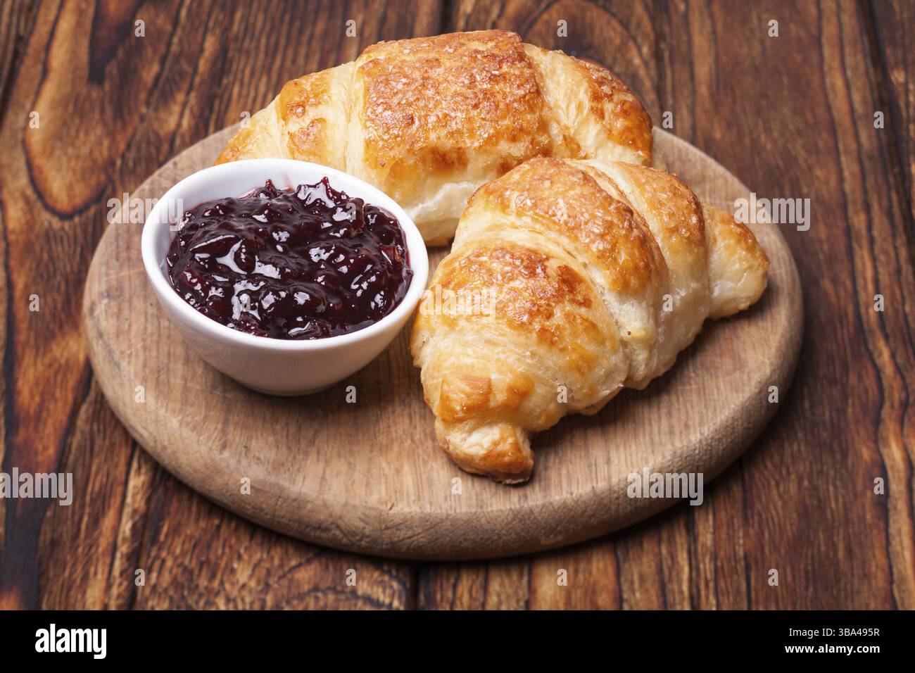Deux délicieux croissants sur une planche à découper en bois Banque D'Images