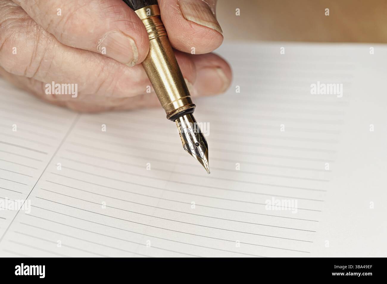 Stylo à encre plume de couleur or dans la main de femme senior sur le point d'écrire quelque chose sur la page vide de planificateur quotidien, détail en gros plan, Liptovsky Hradok, Slovaquie, Banque D'Images