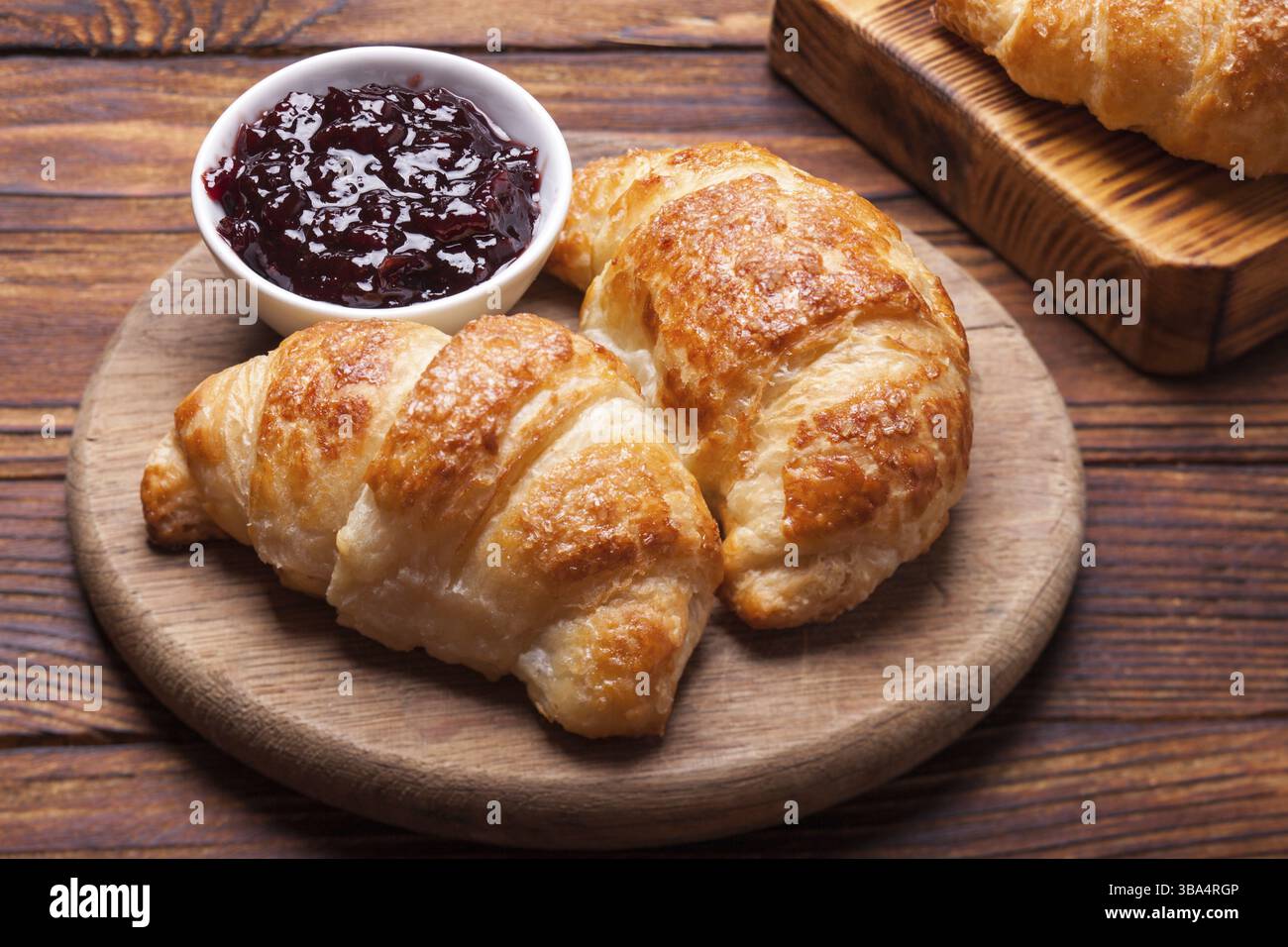 Deux délicieux croissants sur une planche à découper en bois Banque D'Images