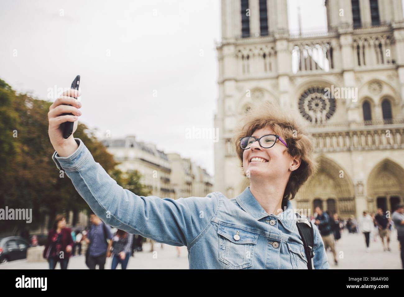 Tourisme à Paris faire un selfie drôle près de la cathédrale notre Dame. Belle jeune femme de tourisme caucasien avec sac à dos à Paris faisant drôle selfie han Banque D'Images