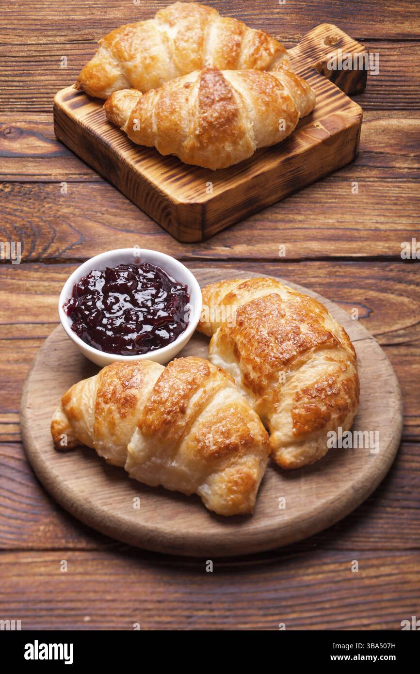 Deux délicieux croissants sur une planche à découper en bois Banque D'Images