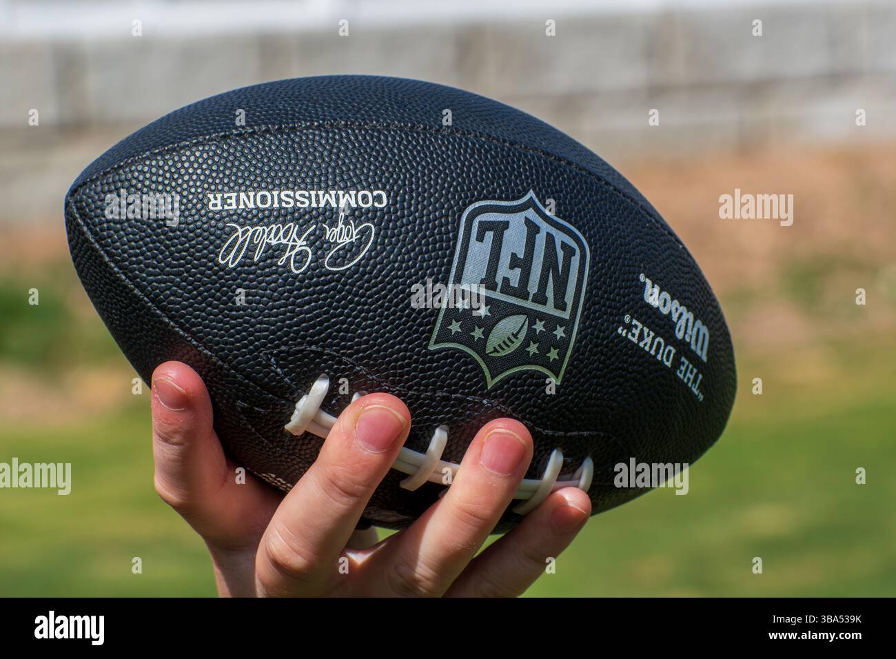 LOS ANGELES, CA, États-Unis – 11 MAI 2025 : une femme tient un match de football officiel de la NFL avec la marque Wilson sur un terrain de football à Los Angeles, en Californie. Banque D'Images