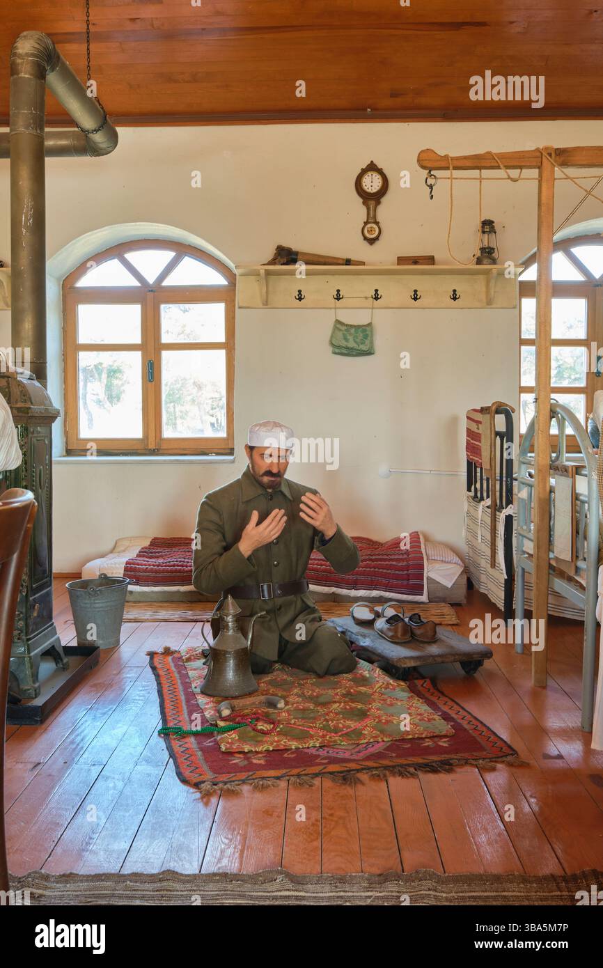 Un patient soldat turc, musulman, priant sur un tapis, tapis sur le sol d'une salle de convalescence. Au Musée de l'hôpital Çanakkale à Gallipoli, Turquie. Banque D'Images