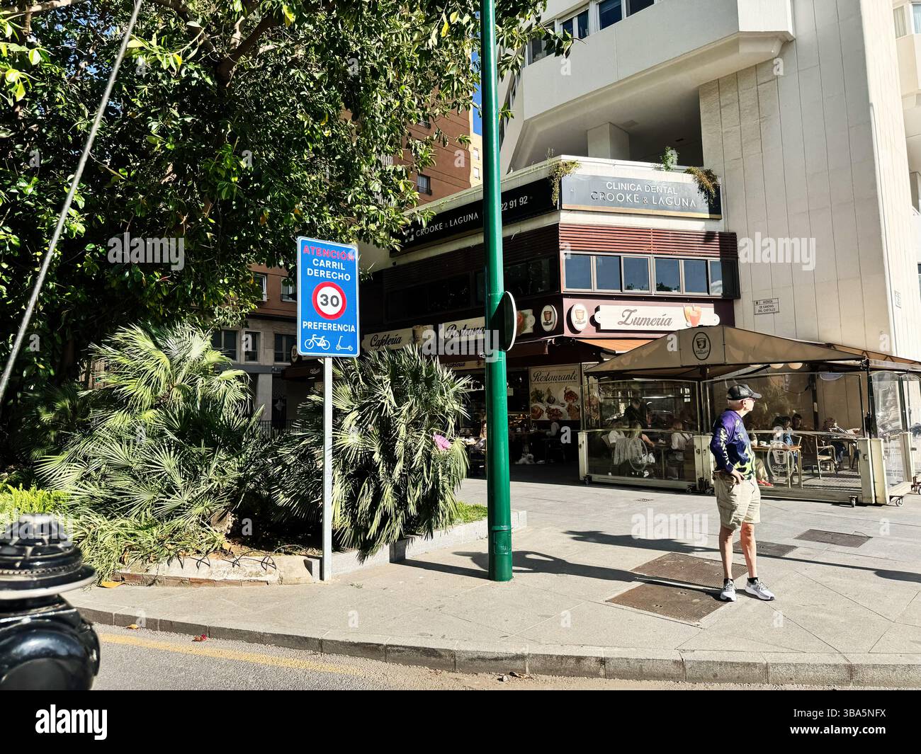 Malaga, Espagne - 02 mai 2025 : coin de rue à Malaga, Espagne, mettant en valeur une végétation luxuriante et une atmosphère de café local Banque D'Images