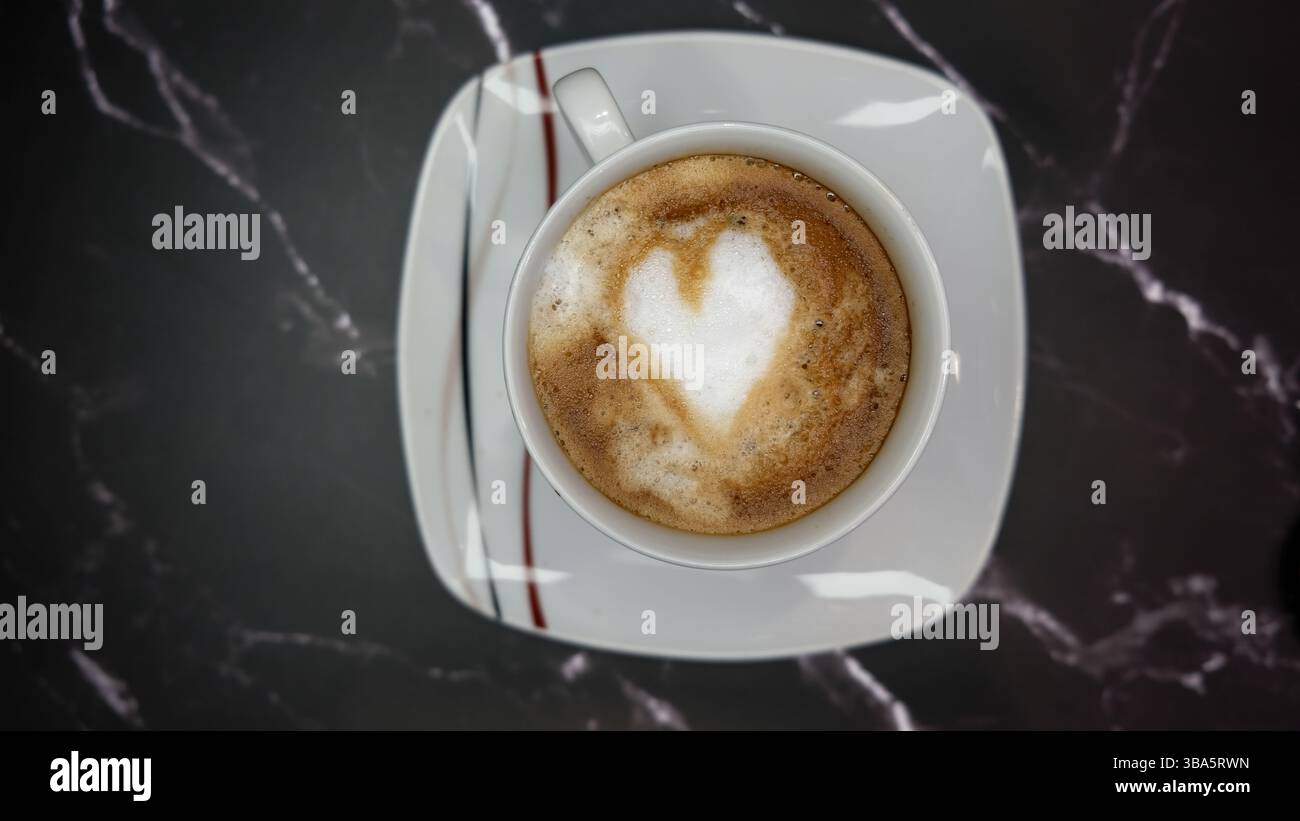 Tasse de Cappuccino avec Heart Latte Art sur fond noir Banque D'Images