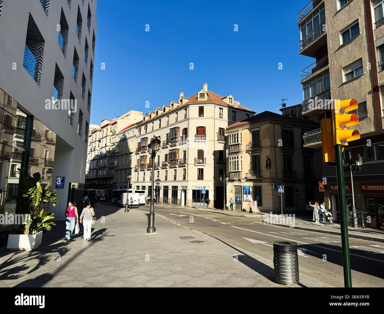 Malaga, Espagne - 02 mai 2025 : scène urbaine ensoleillée d'un croisement de rue à Malaga avec des gens et de l'architecture Banque D'Images