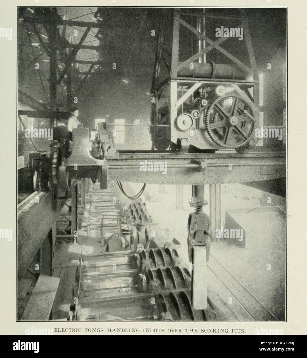 PINCES ÉLECTRIQUES MANIPULANT DES LINGOTS AU-DESSUS DES FOSSES DE TREMPAGE DE L'ARTICLE ÉLECTRICITÉ DANS LA FABRICATION MODERNE DE L'ACIER. Par John Hays Smith de The Engineering Magazine consacré au progrès industriel volume XXIV octobre 1902 - mars 1903 The Engineering Magazine Co Banque D'Images