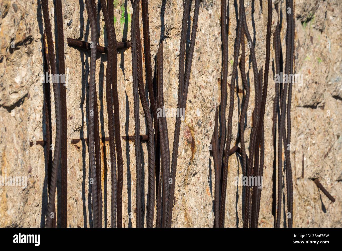 Une ouverture déchiquetée dans le mur d'excavation érodé encadre la façade historique de plusieurs étages du bâtiment au-delà à la Topographie de la Terreur à Berlin, en Allemagne. Banque D'Images