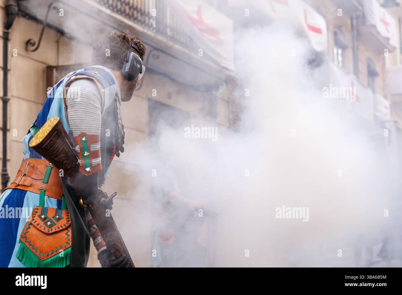 Alcoy, Espagne, 05-05-2025 : Chef de la troupe Tomasinas, le dos tourné, tirant sur l'arquebus au festival Maures et Chrétiens à Alcoy 2025 Banque D'Images