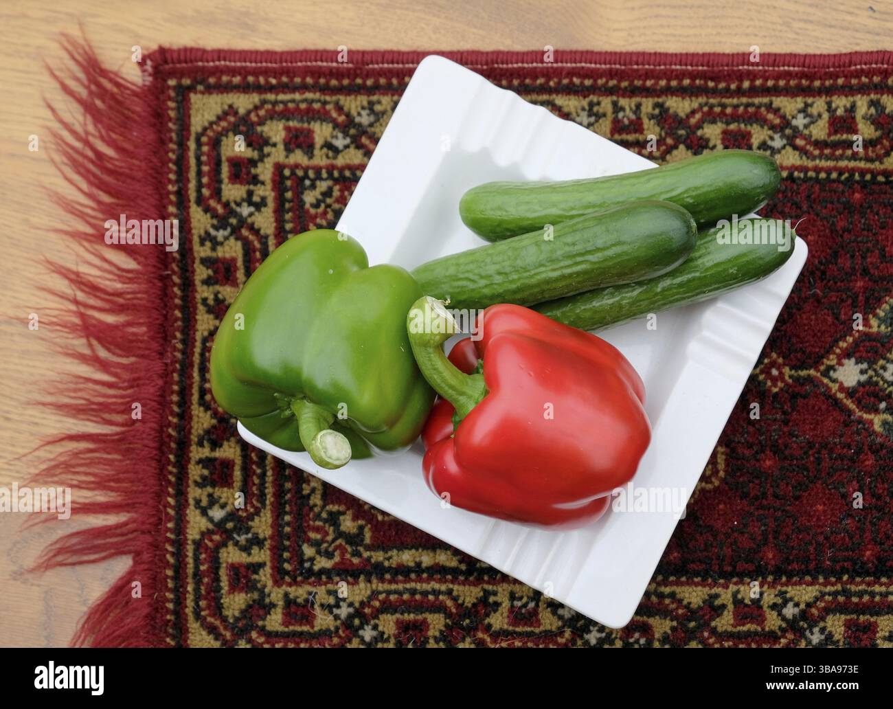 La composition avec différents légumes crus sur plaque blanche sur tapestry. paprika et concombre à Amsterdam Pays-Bas Banque D'Images