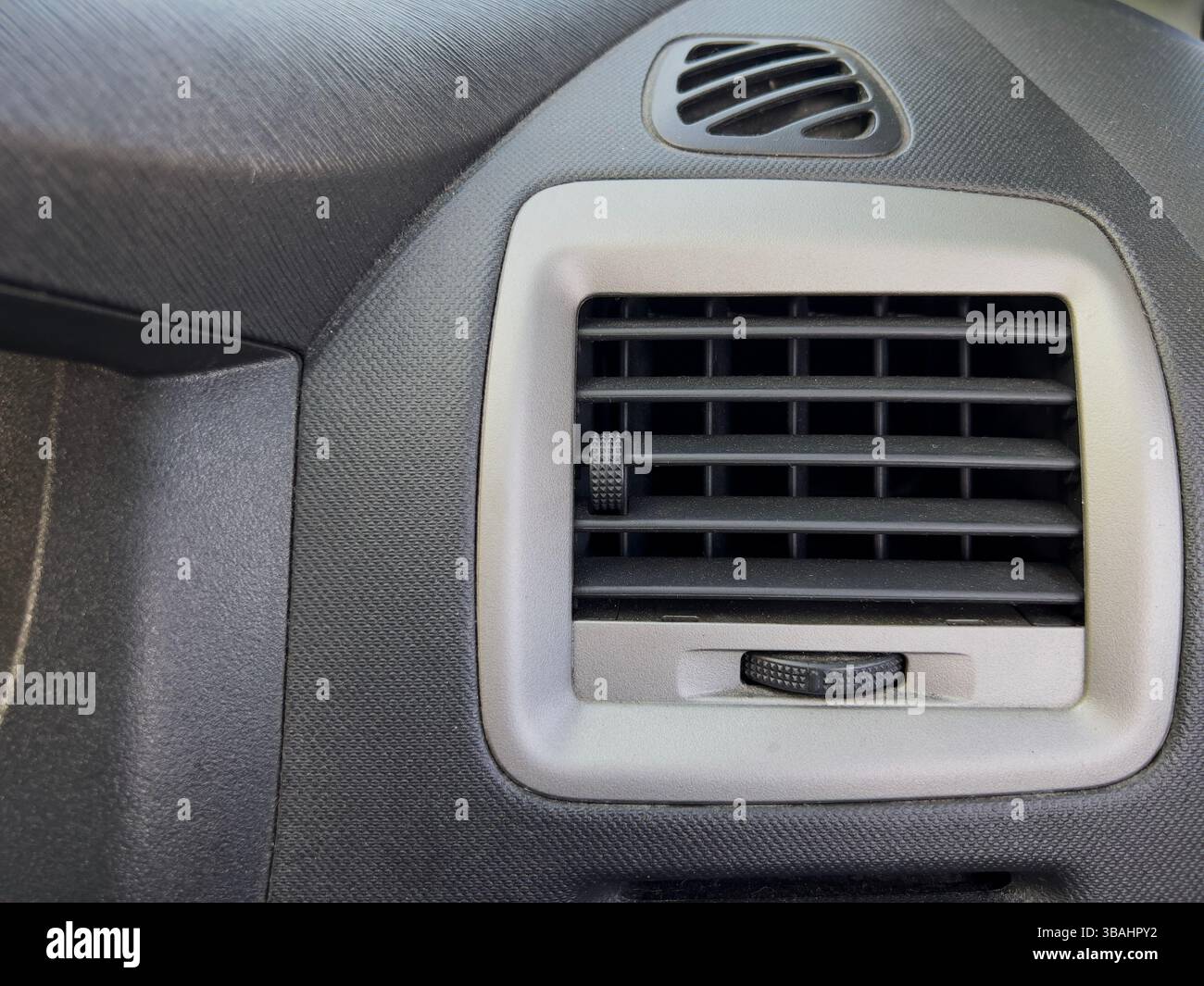 Gros plan détaillé d'un évent de voiture montrant le bouton de commande et les lames d'évent. - Image de stock capturée avec un smartphone