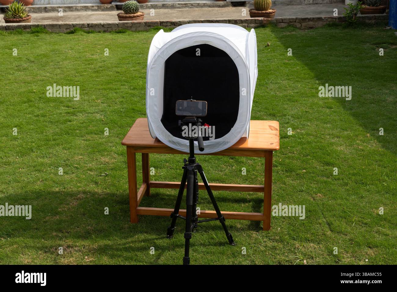 Utilisation du téléphone portable pour la photographie de produit avec tente de lumière translucide dans la lumière naturelle Banque D'Images