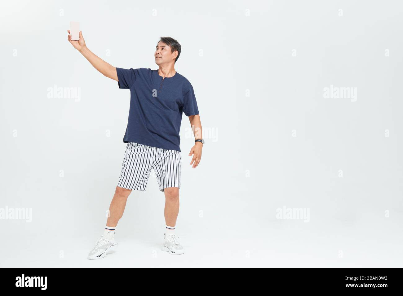 Un vieil homme souriant en prenant un selfie au téléphone Banque D'Images